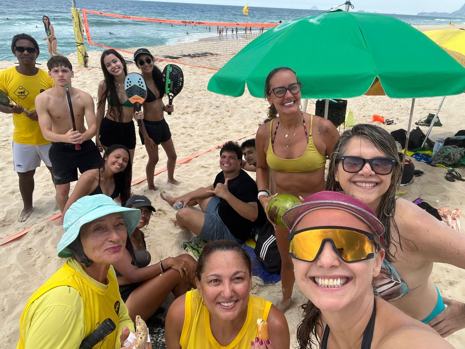 Maicon Cândido com um grupo reunido após uma atividade de beach tennis na praia